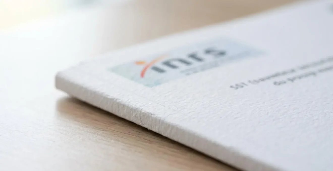 Gros plan sur le coin supérieur d'un manuel de formation SST officiel posé sur un bureau moderne, avec une zone de logo visible mais floutée